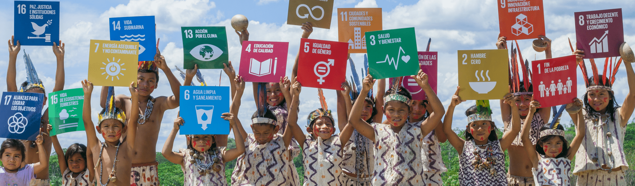 A group of children holding the logo of the Sustainable Development Goals