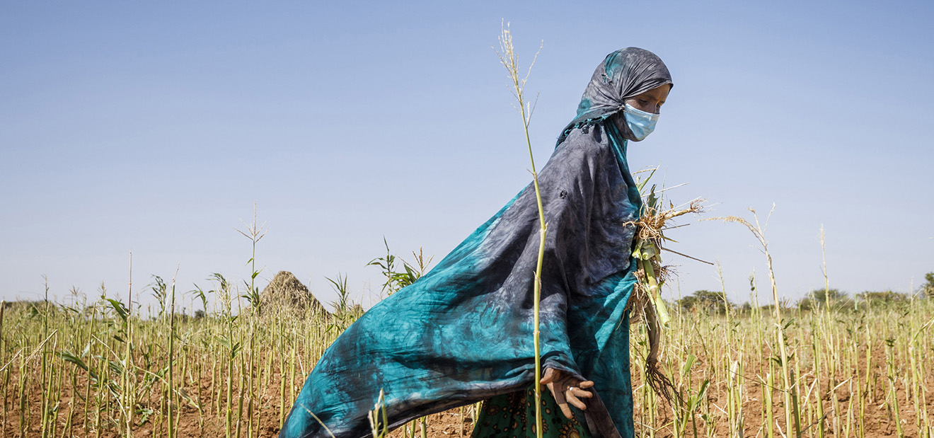woman wearing a mask walking in a field