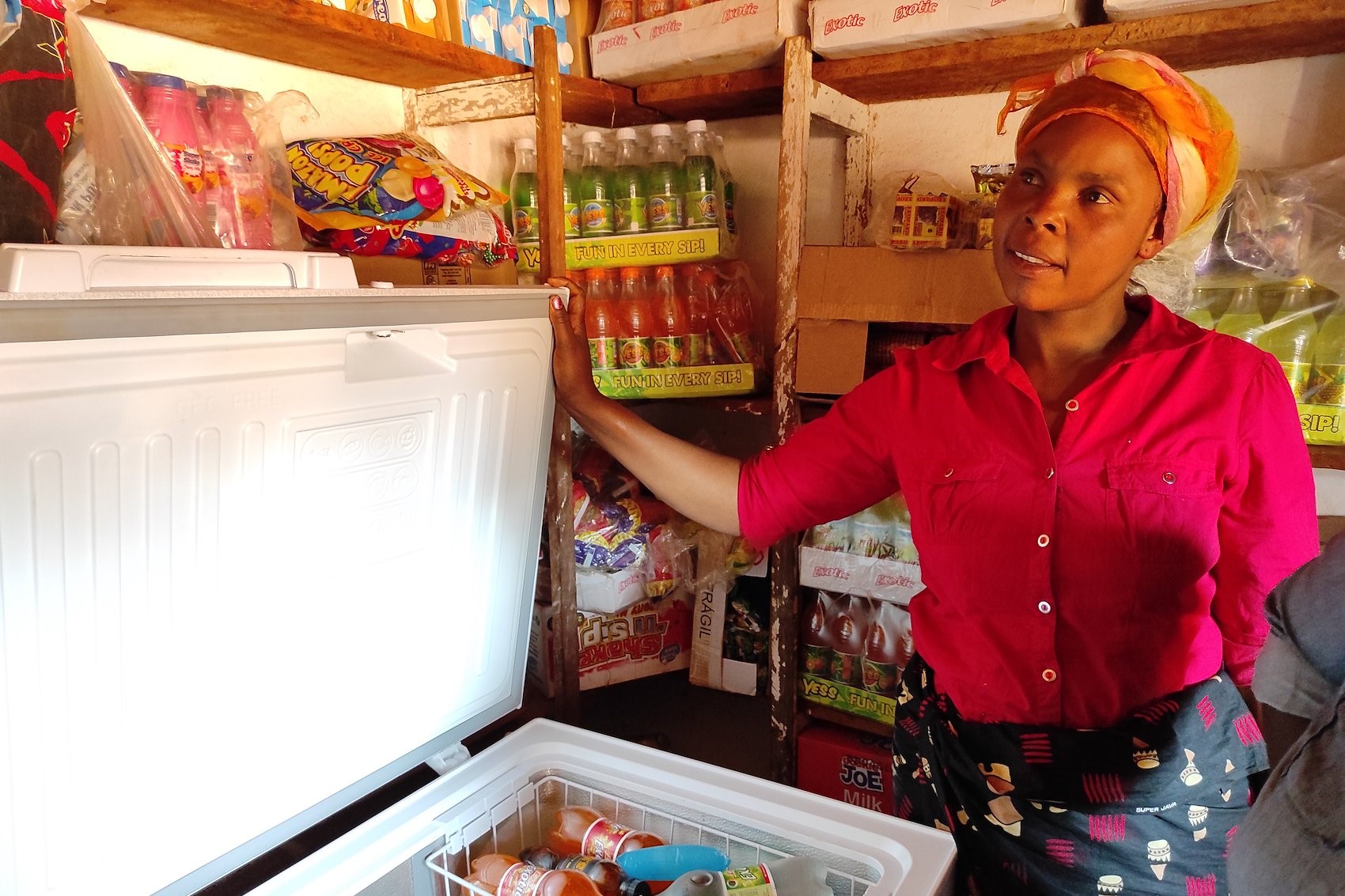 Une femme ouvre un réfrigérateur dans une épicerie