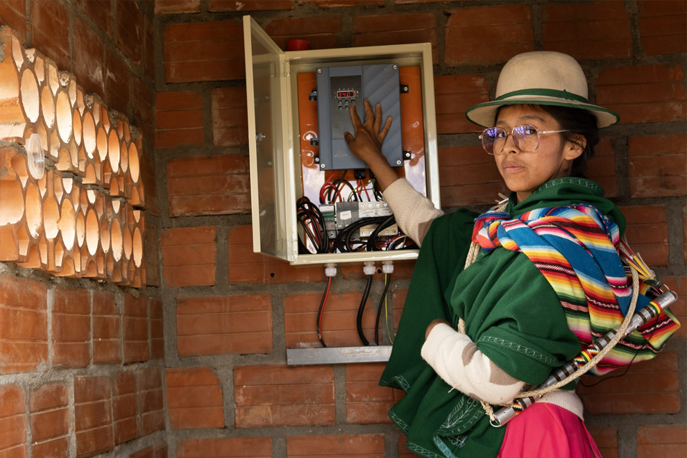 A woman with traditional Bolivian clothes on a solar-powered station