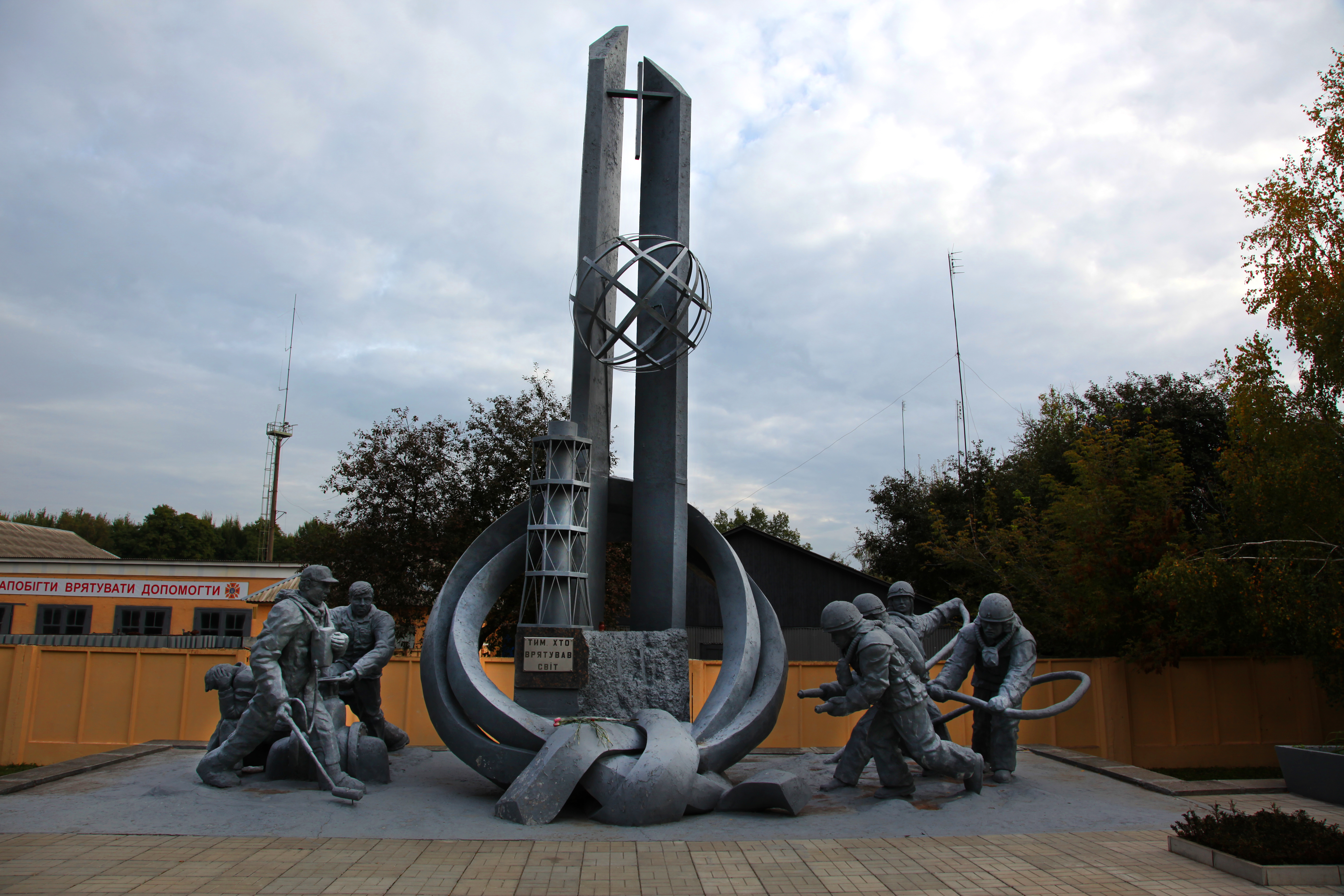 A memorial of firefighters next to towers and a reactor