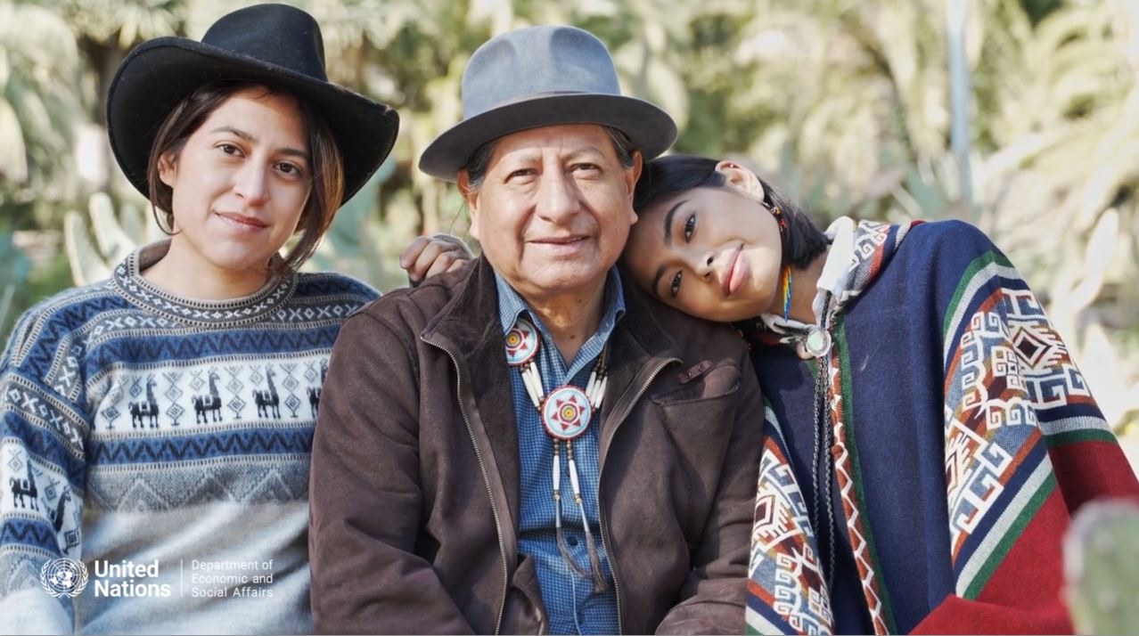 Familia con indumentaria Indígena que representa a dos generaciones, una joven y otra mayor