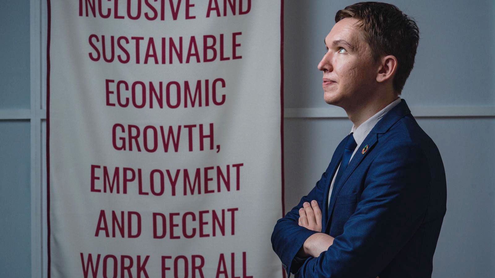 Vlad stands next to a poster advocating for sustainable development