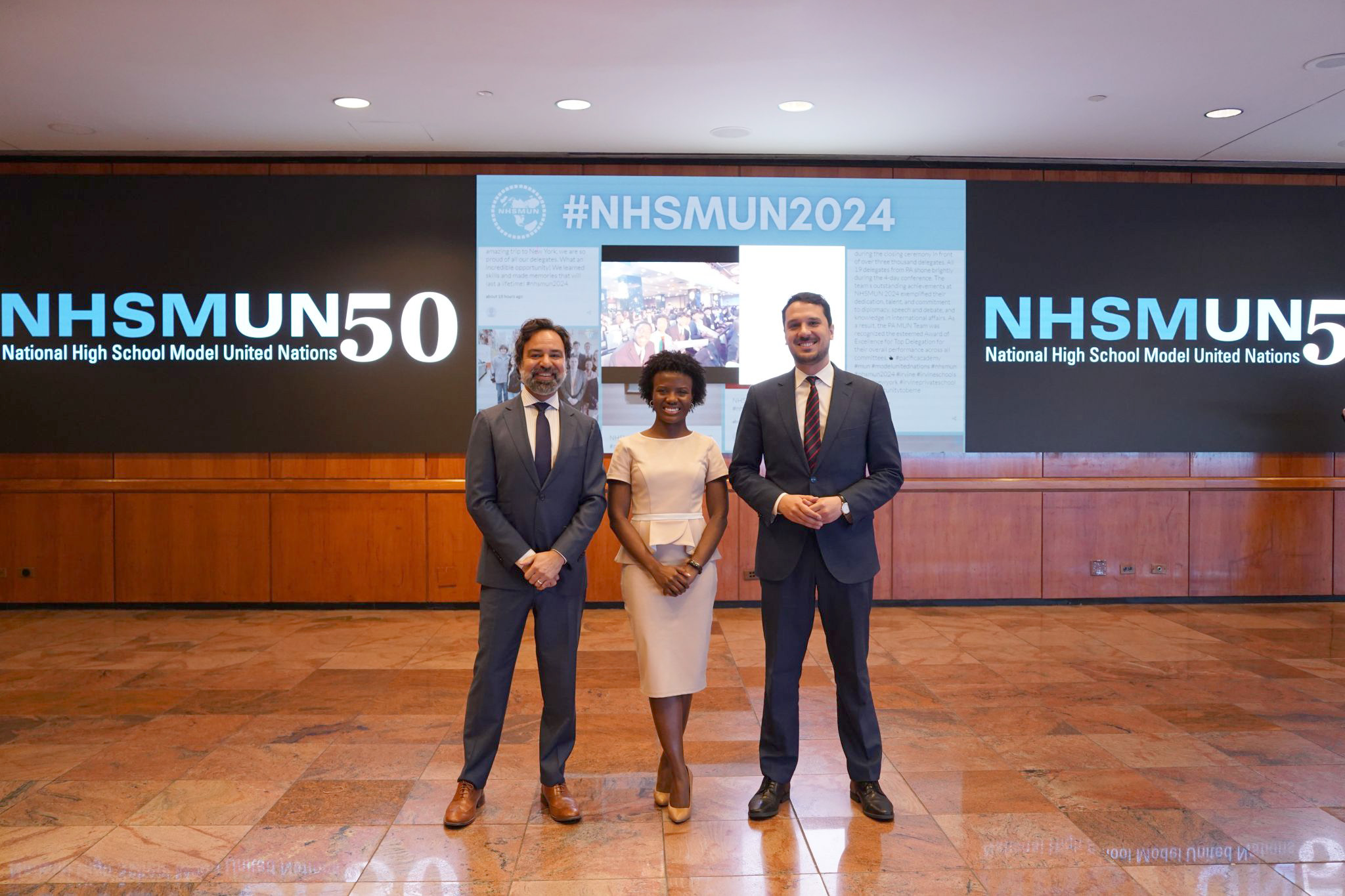 UN representatives stand in front of the event signage