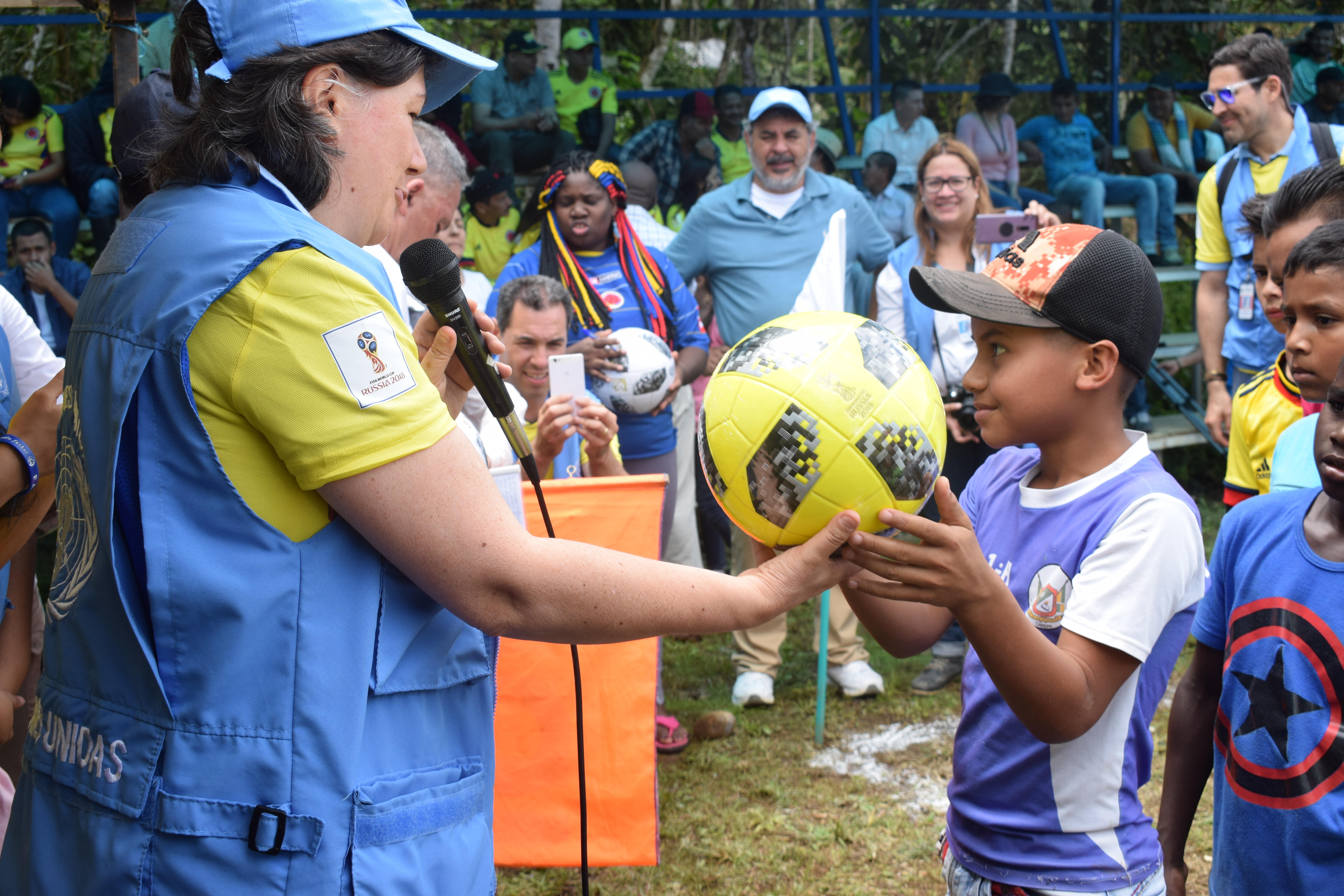 A resident of Dabeiba, Colombia, is gifted a football at a match between former FARC-EP combatants and members of the Colombian Armed Forces, organized by the UN Verification Mission in Colombia. 19 June 2018. UN Photo/Jennifer Moreno Canizales. 