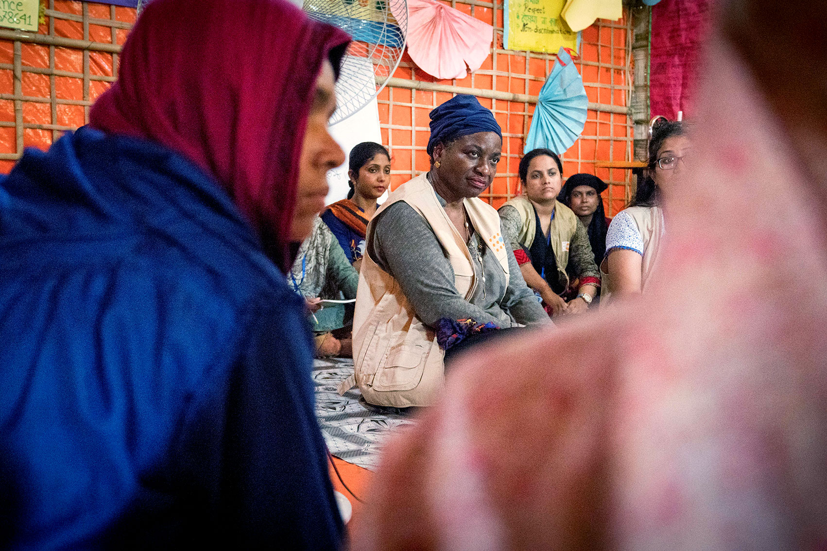 Dr. Natalia Kanem sitting on the floor with many women around her.