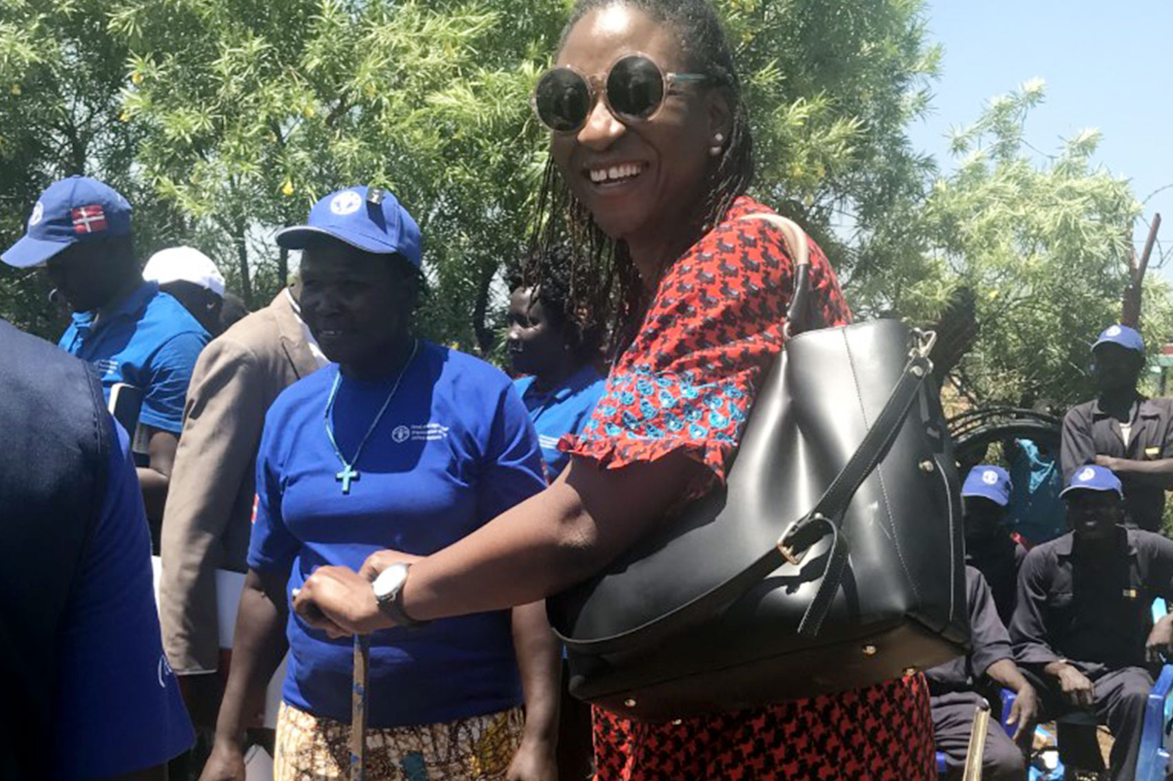 Funmi Balogun is at a farm site with local farmers surrounding her