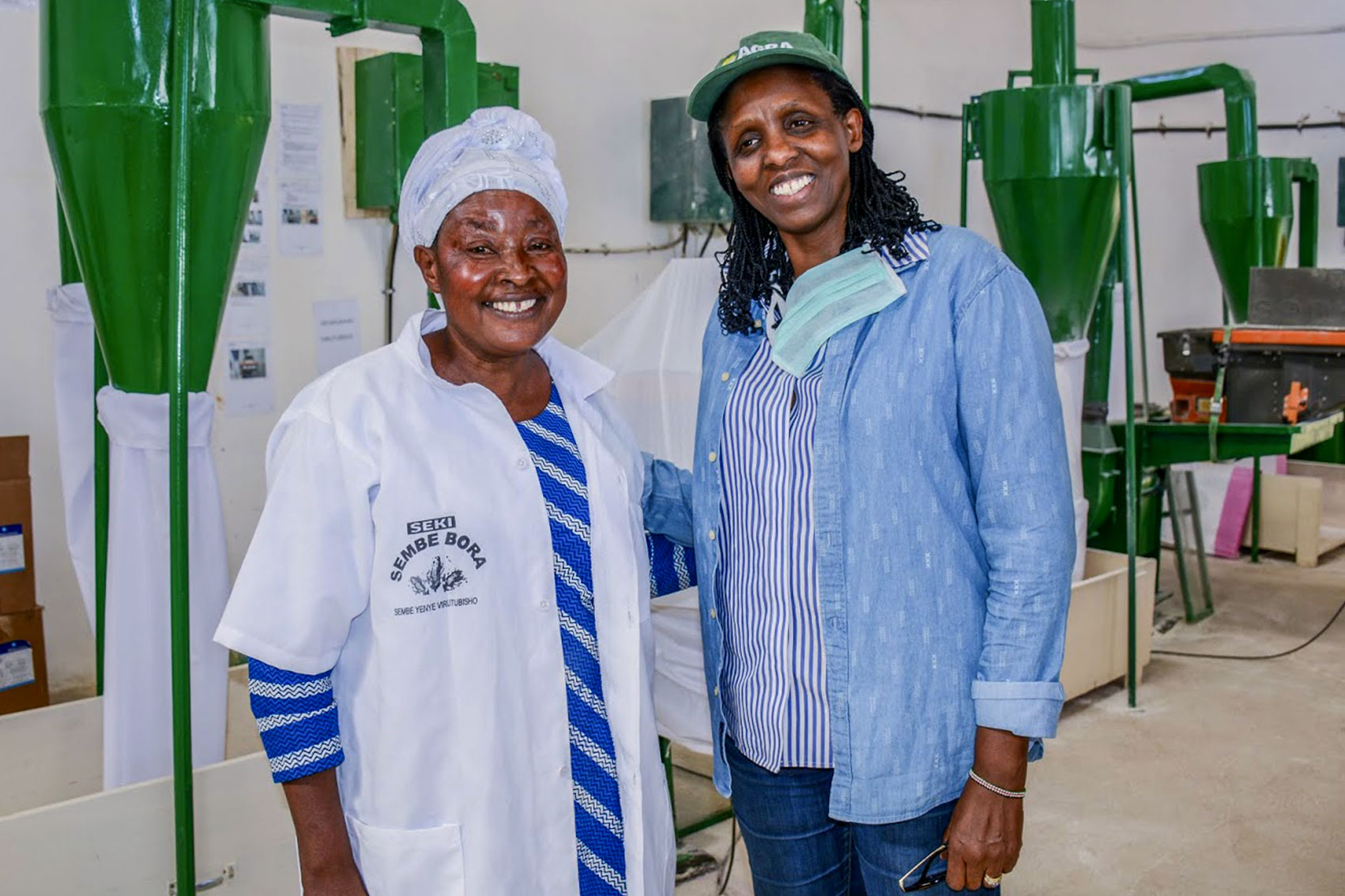 Dr. Kalibata poses for a photo with a female worker in an milling plant.