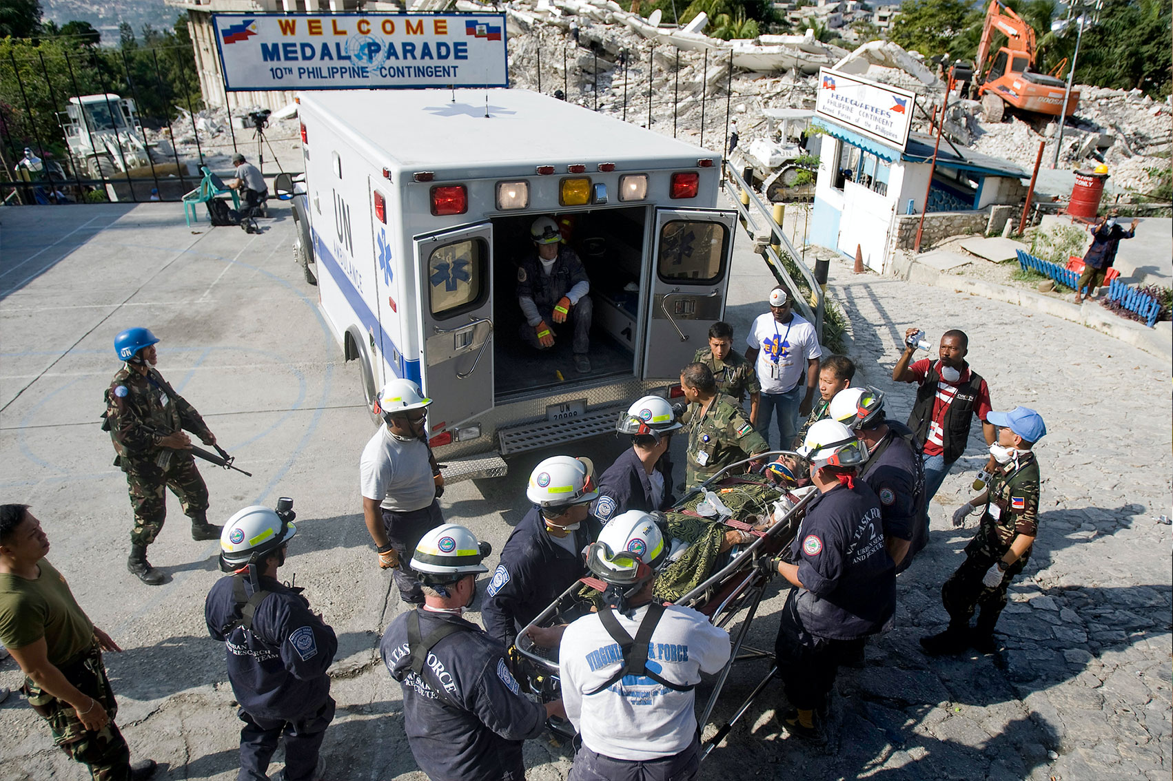 Search and rescue team carries a UN staff member into an ambulance