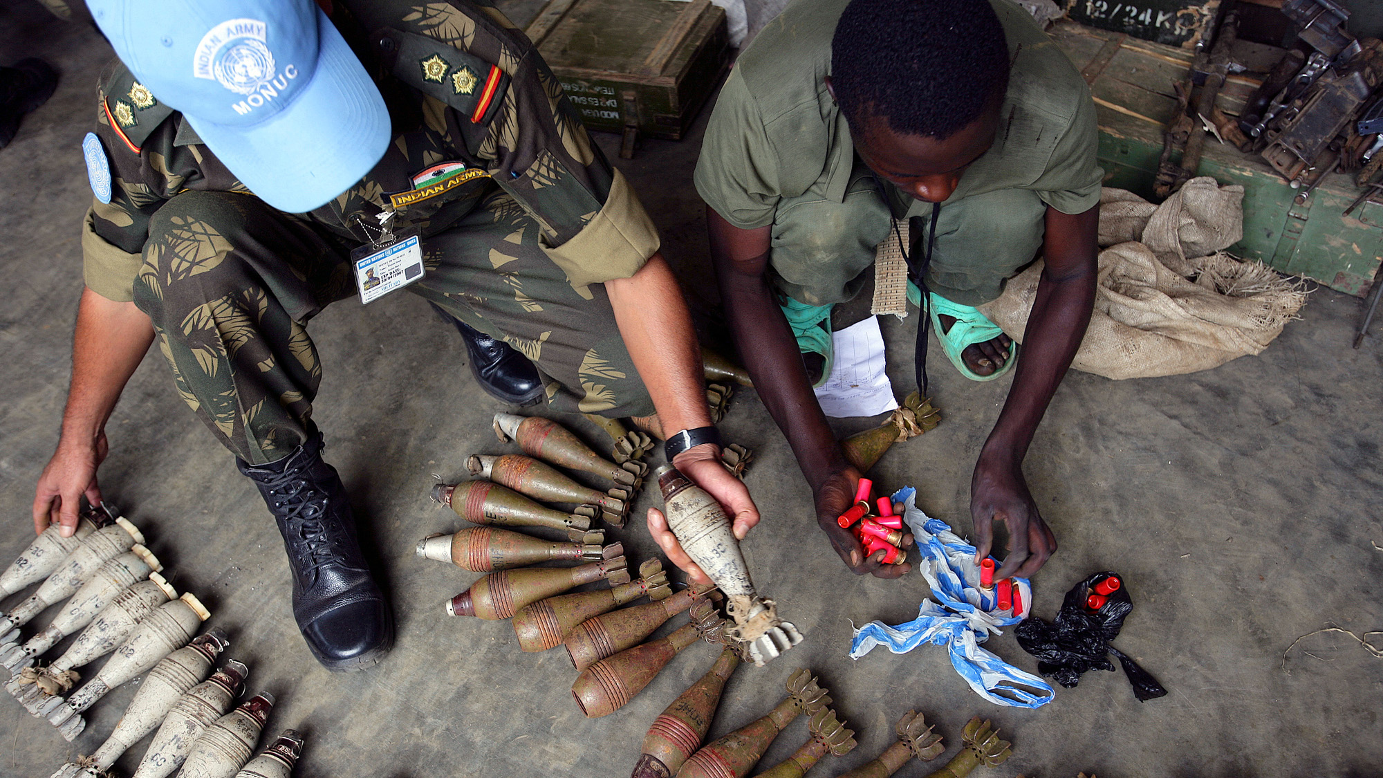 men seen from above, sorting weapons and ammunition