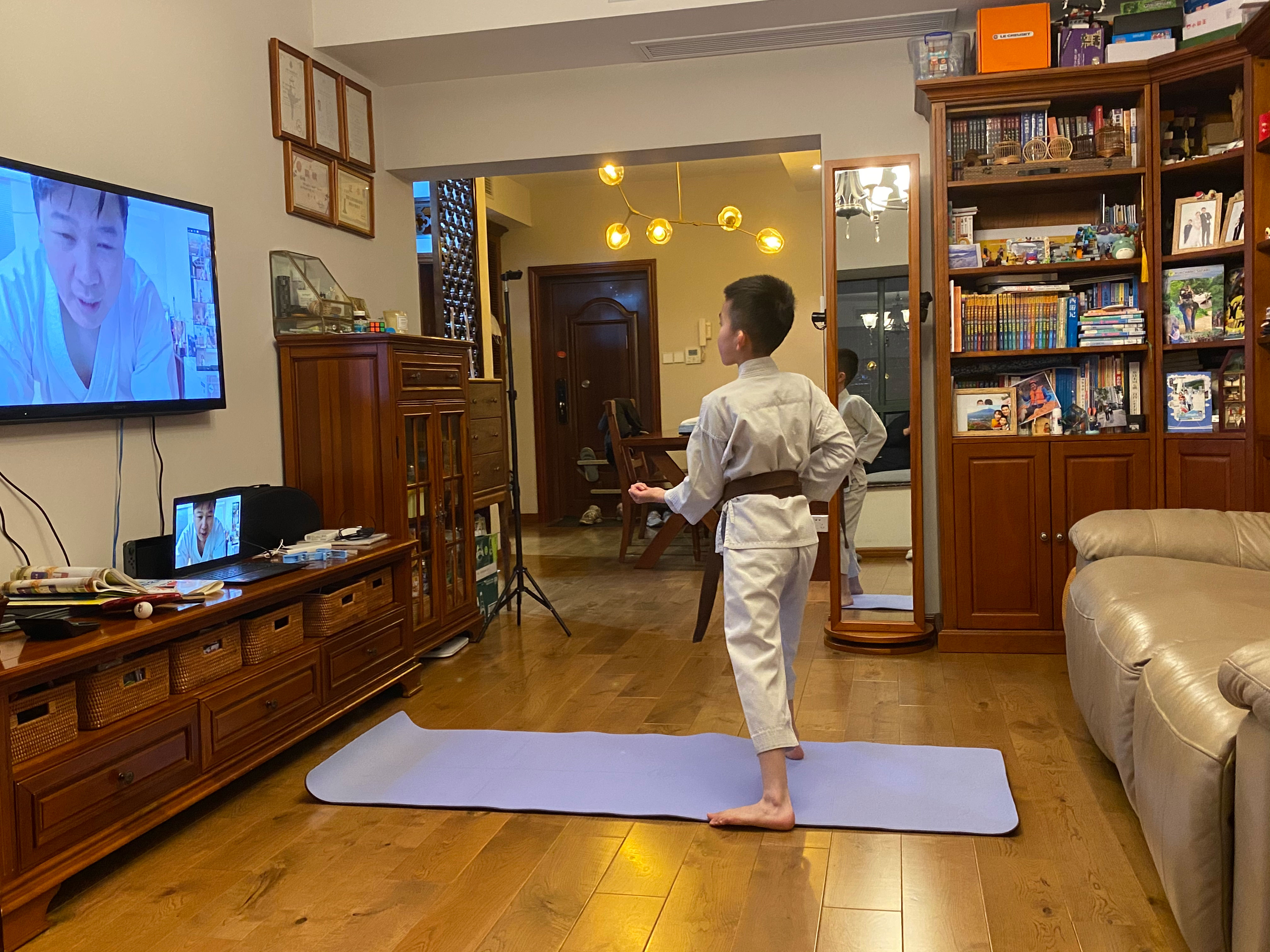 A child doing Karate in front of the TV