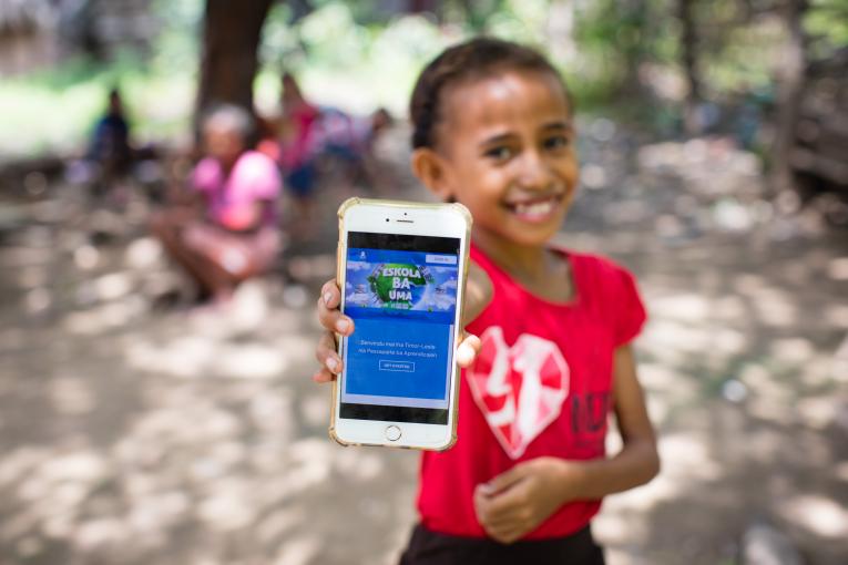 young girl holds up cell phone