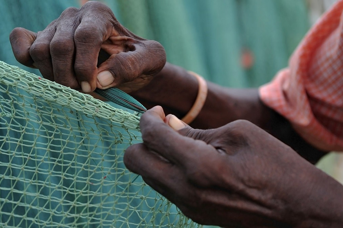 A fisherman fixes a net