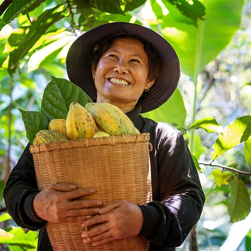 Una agricultora sonriente con semillas de cacao