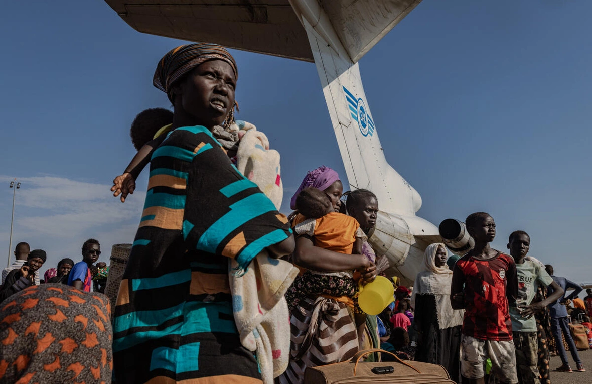 Une femme et son bébé attendent de pouvoir monter à bord de l'un des avions transportant des réfugiés