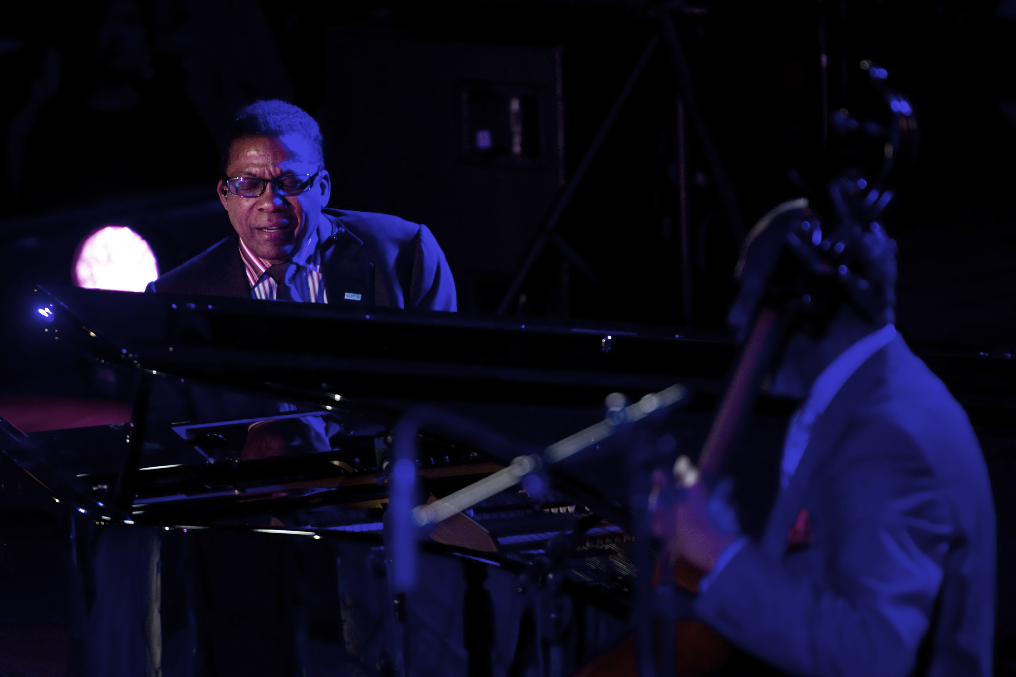 A man at the piano under a spotlight.