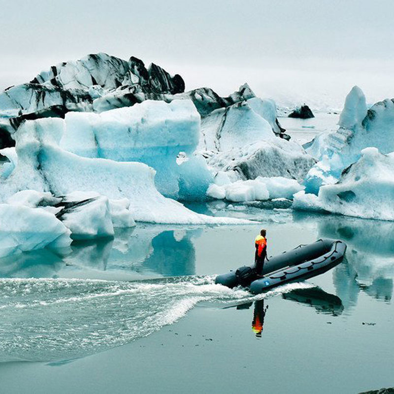 Imagen de un hombre en una lancha entre glaciares.