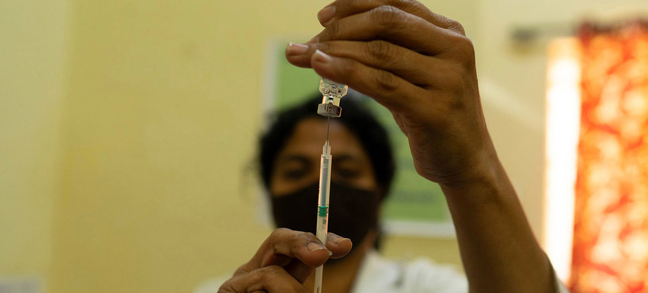 health worker holding vaccine syringe