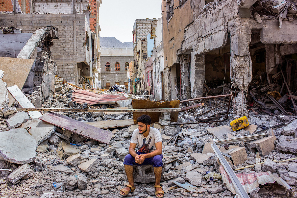 A man sits in the rubble