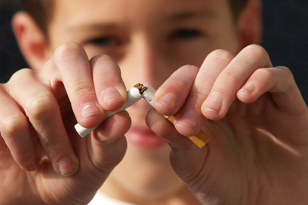 closeup of hands breaking cigarette in half