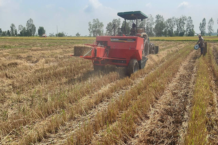 Tractor collecting hay bundles