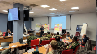 classroom with students and teacher looking at boards together