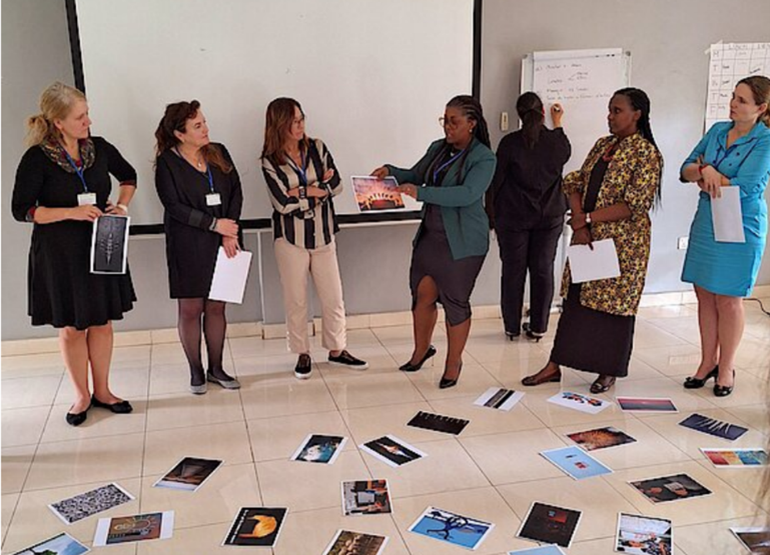 教室里，几位女性站在散落满地照片复印件的地面上