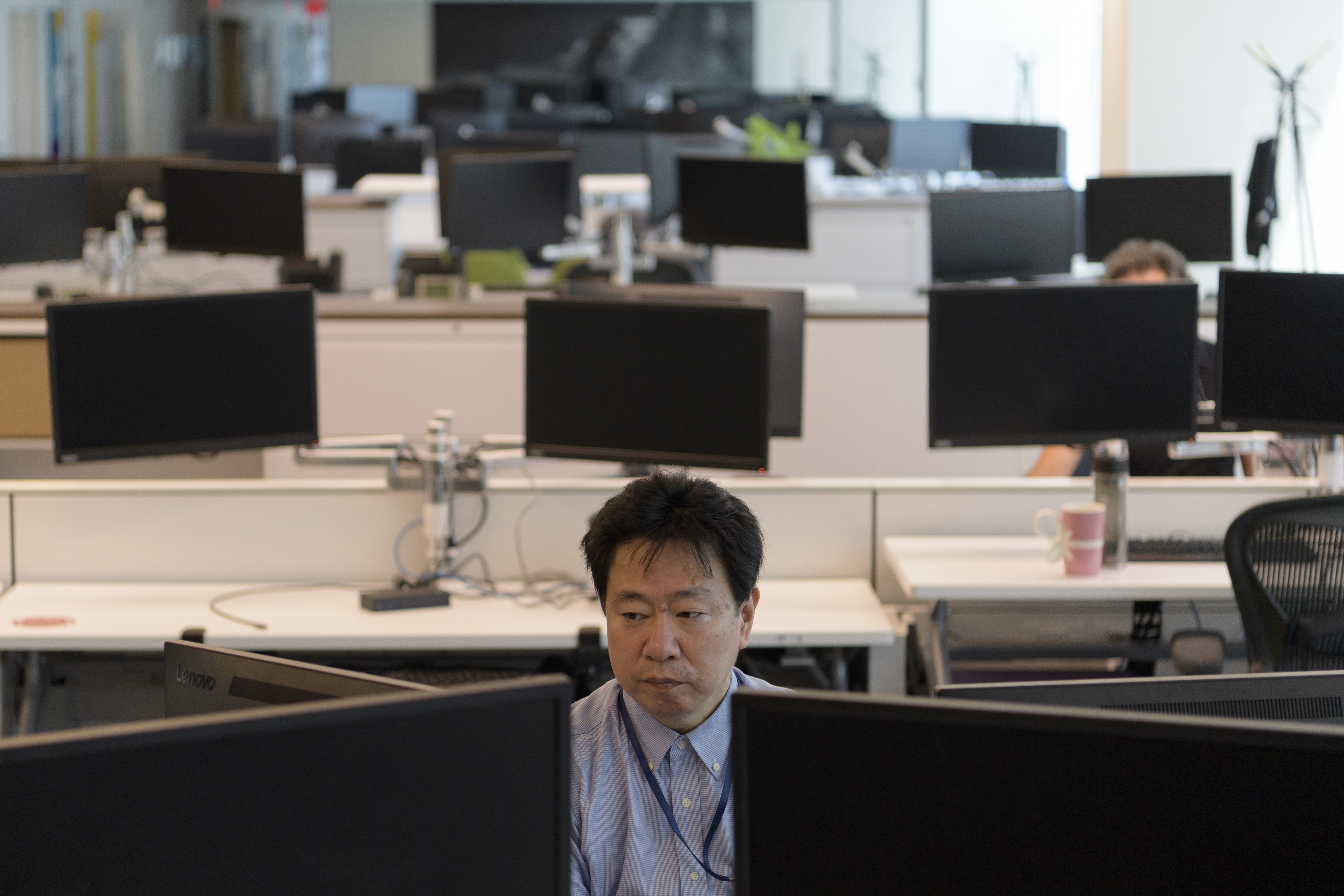 Man sitting at a desk in an open desk space.