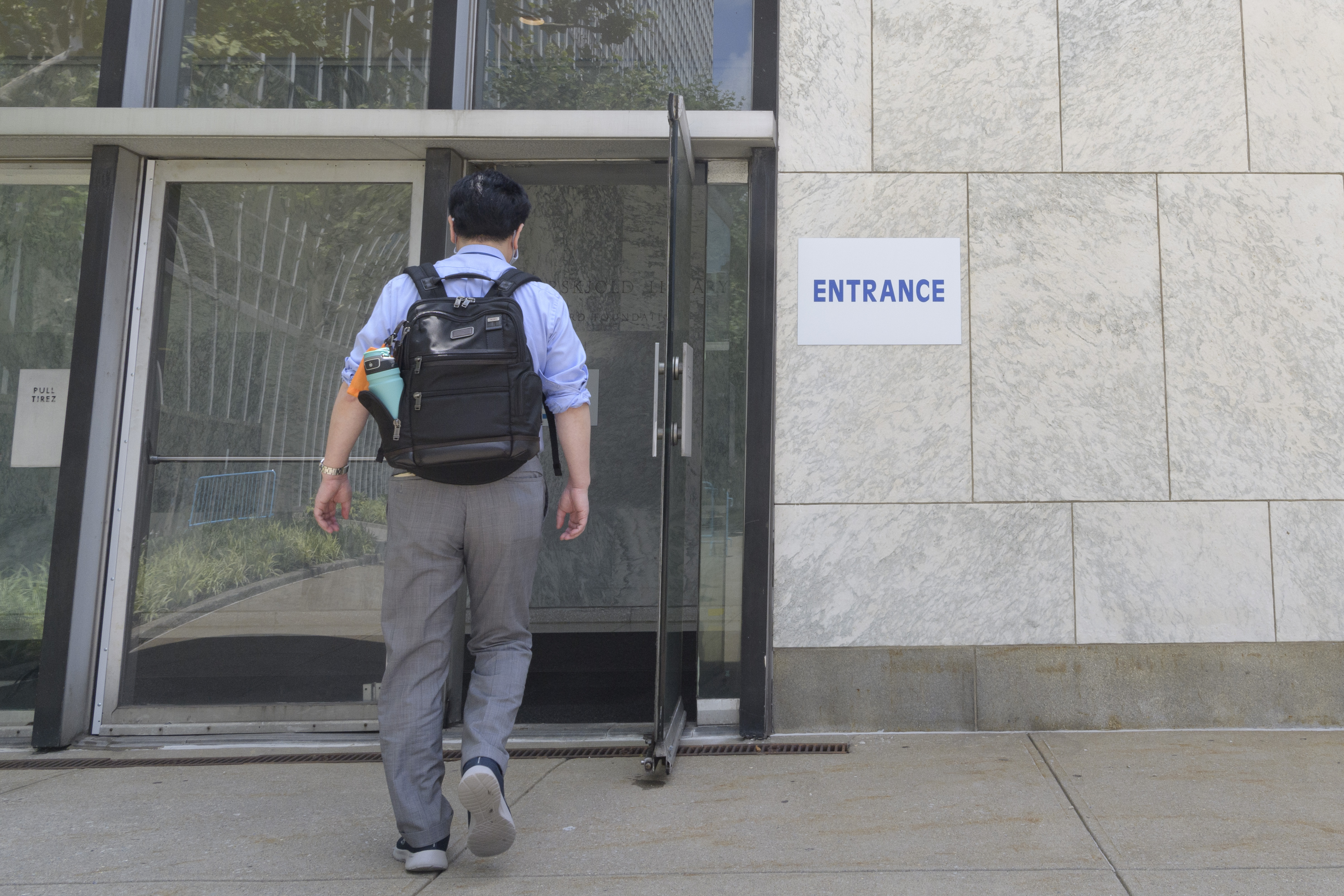 Man passes through entrance of UN Secretariat.
