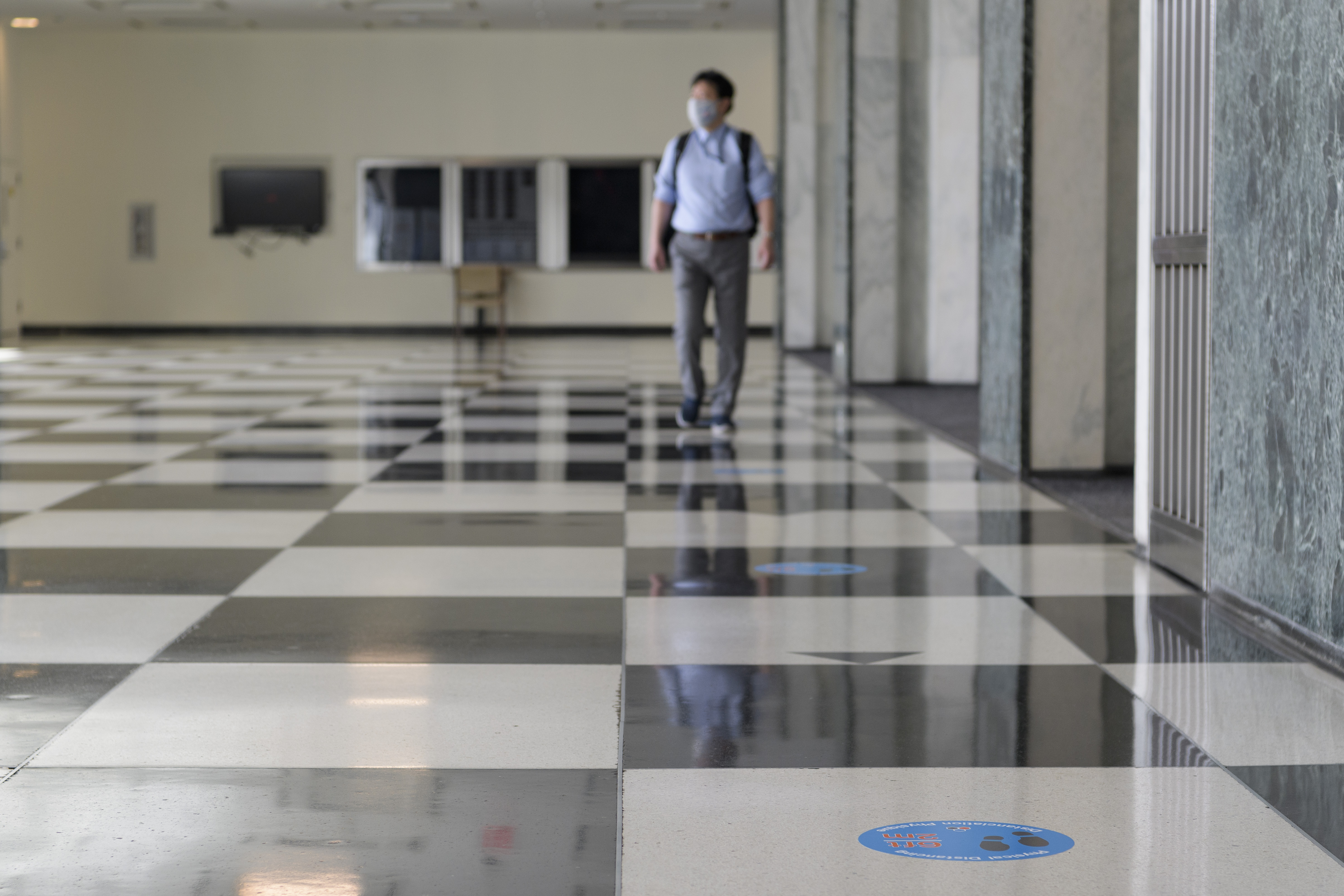 Man walks across a checkered floor