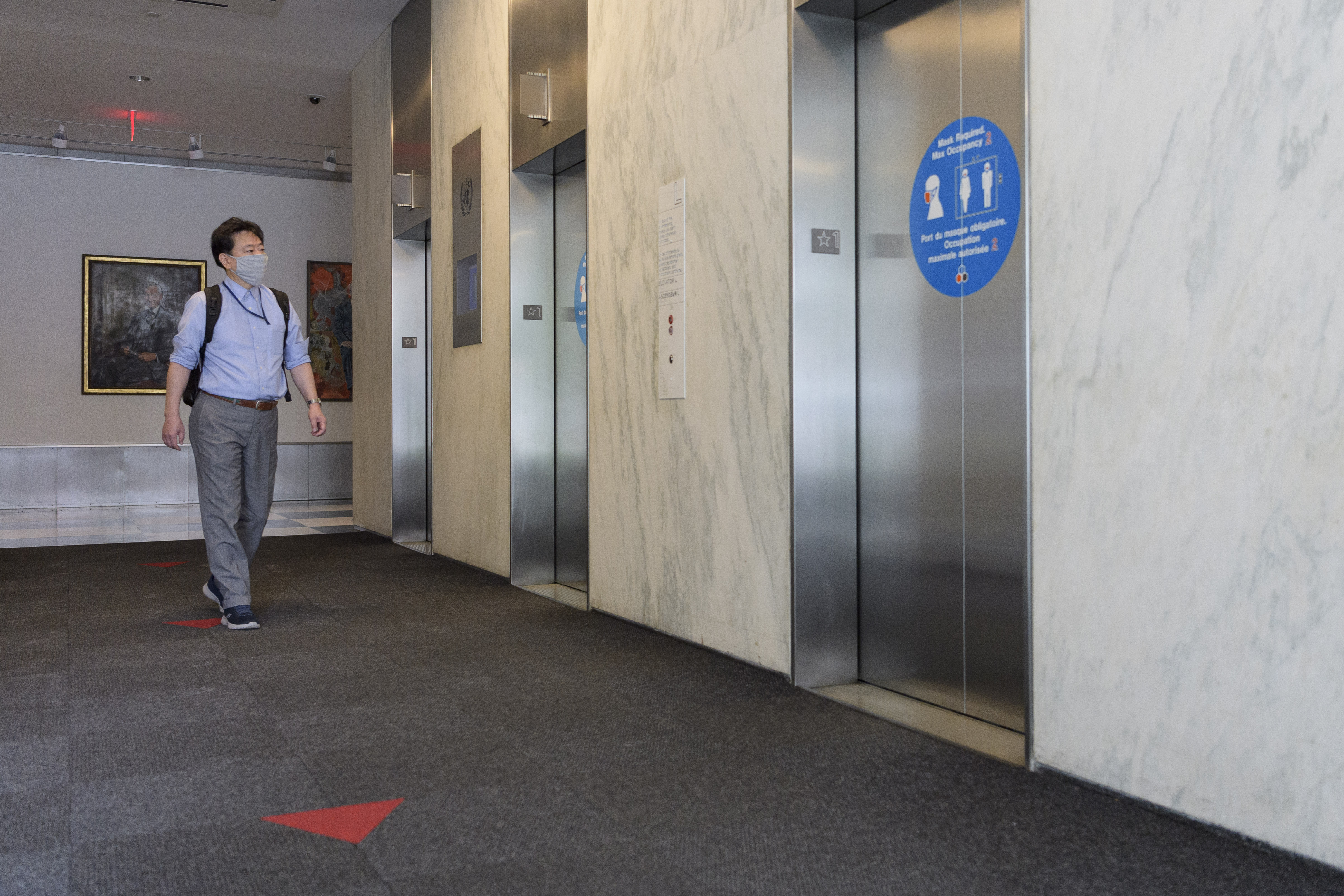 Man approaches an elevator bank.