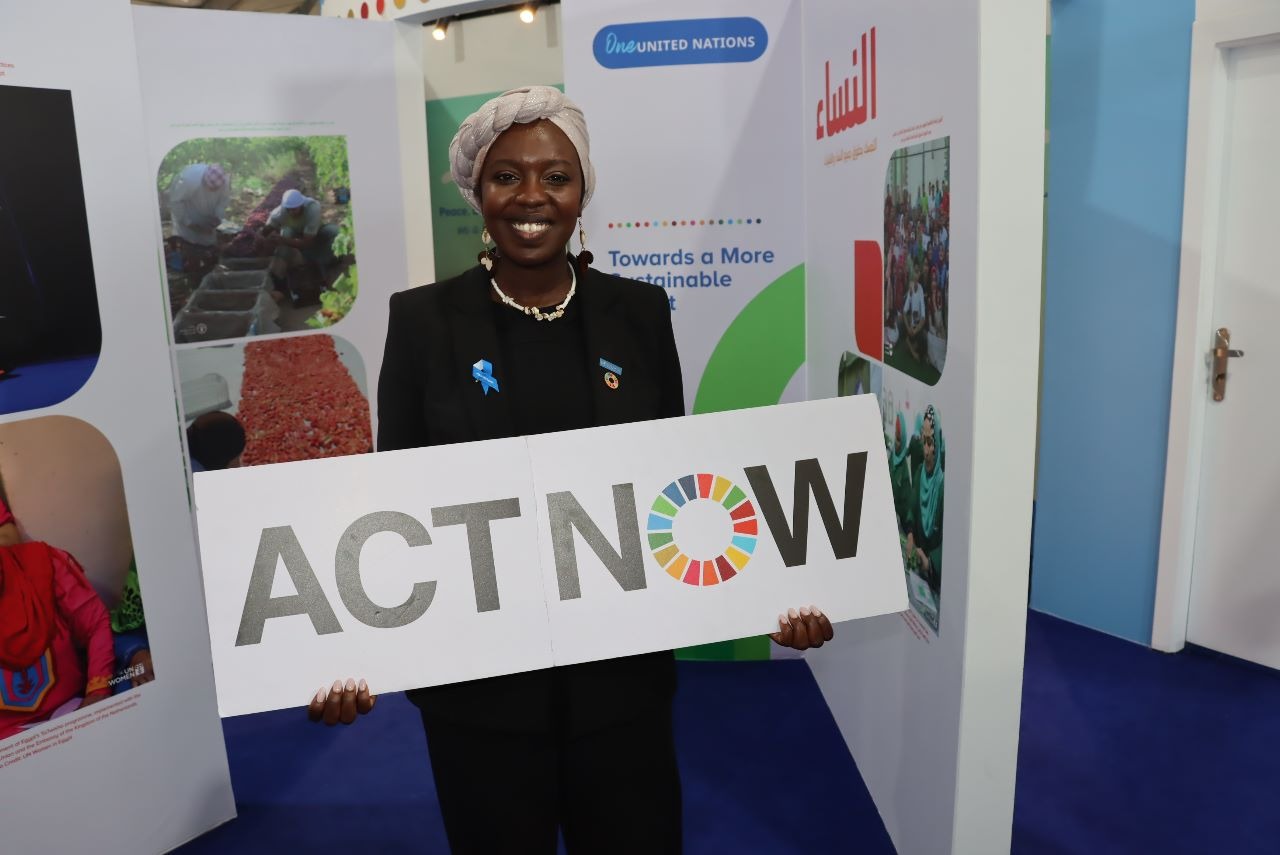 Emi Mahmoud, Goodwill Ambassador, UN Refugee Agency, holding the ACTNOW campaign banner