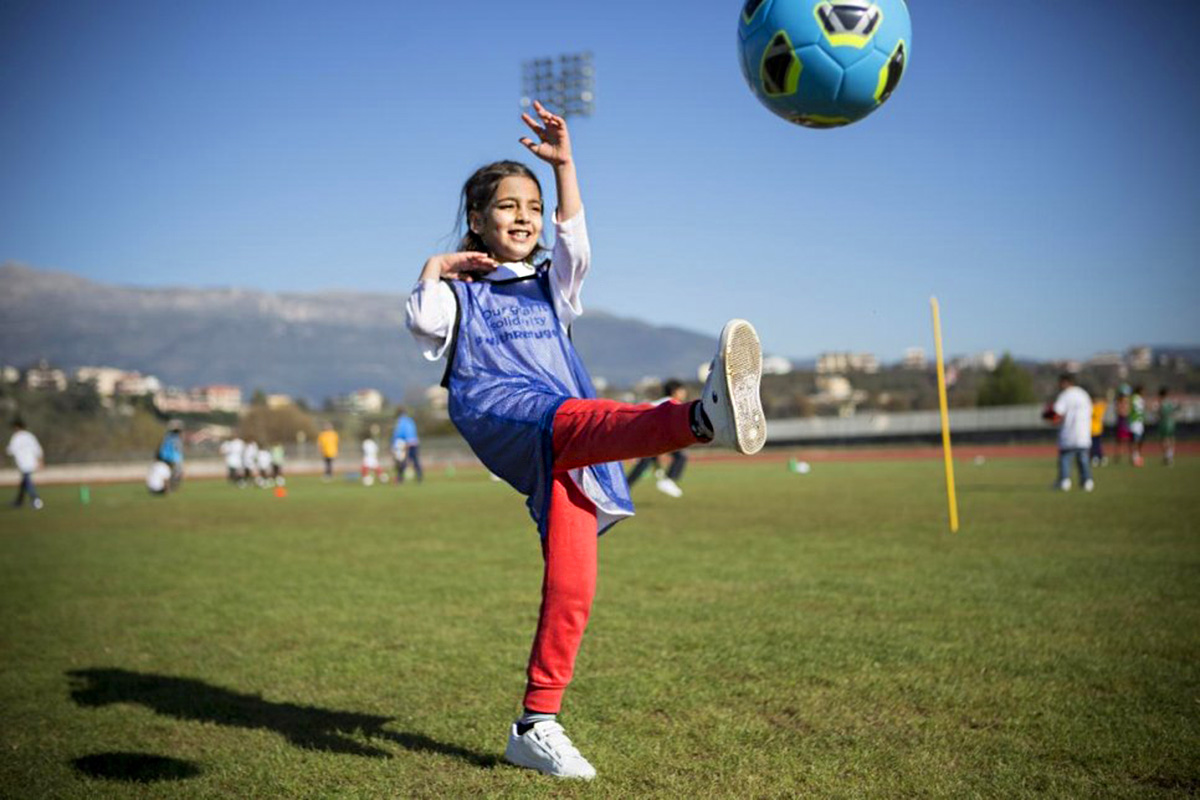 A girl kicking and football.