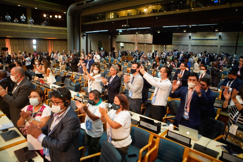 a full conference room with people standing up and clapping