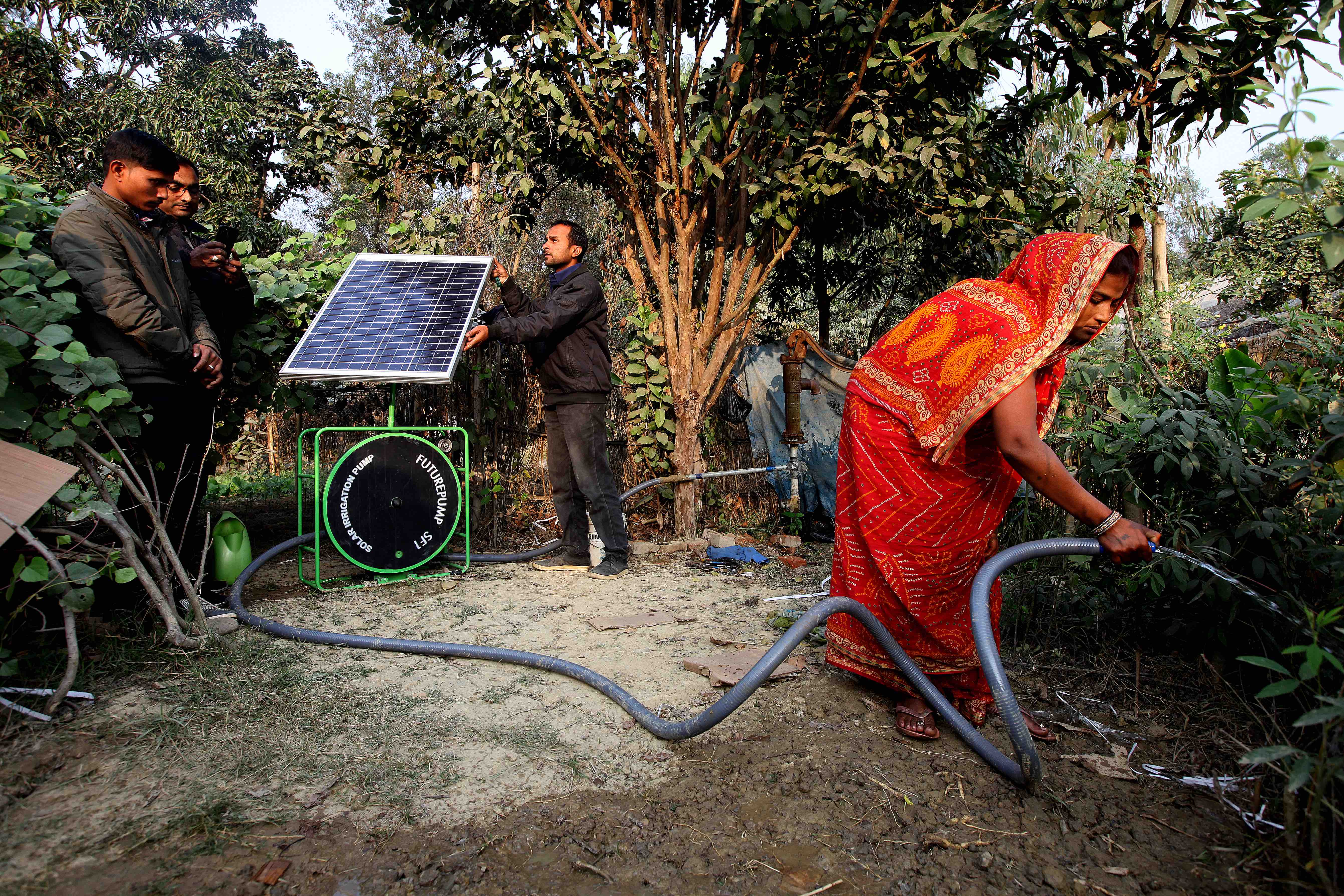 Mujer riega las plantas utilizando un sistema de regado solar