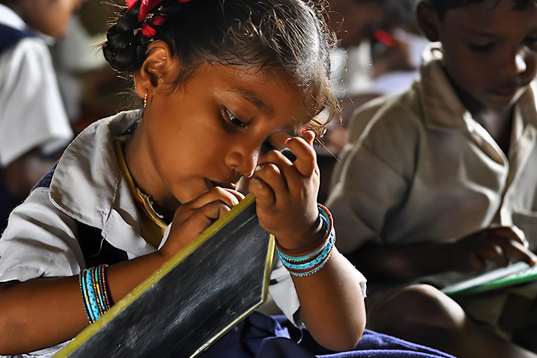 girl in elementary school writing on tablet