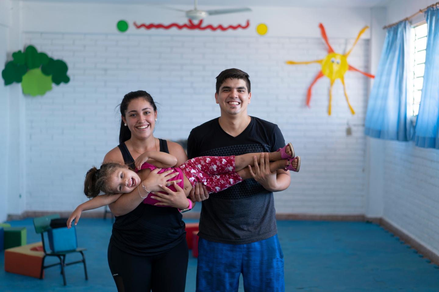 parents holding smiling little girl