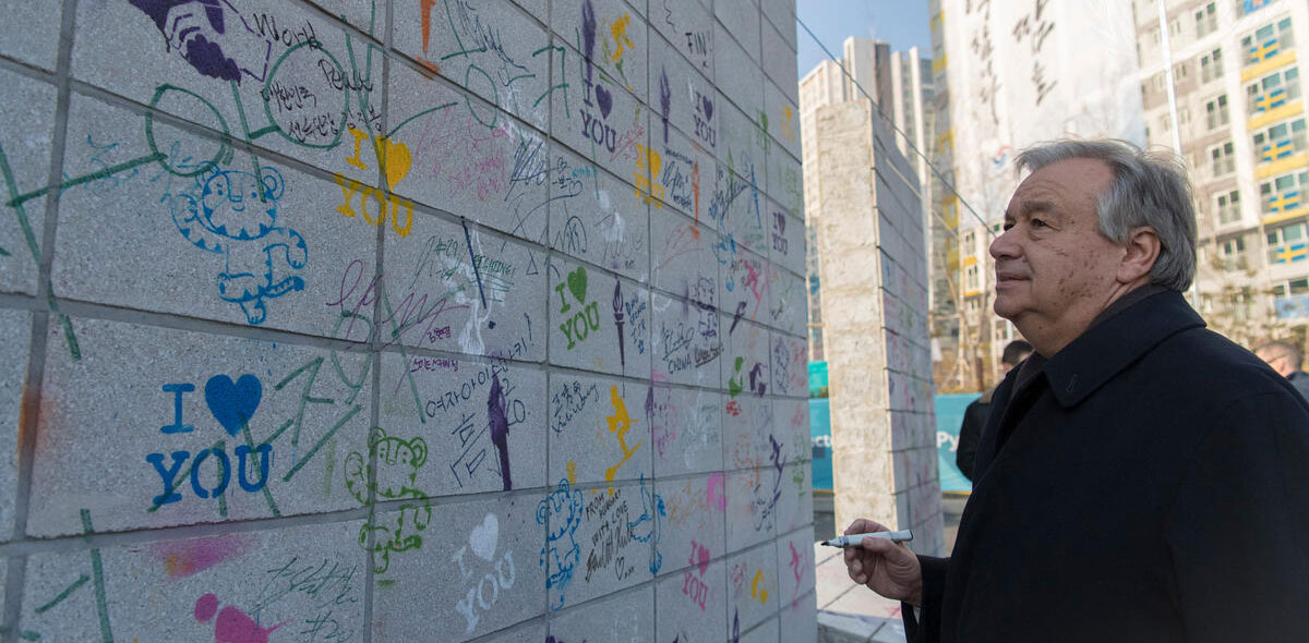 Secretary-General António Guterres writes on the Olympic Truce Wall in the PyeongChang Olympic Village.