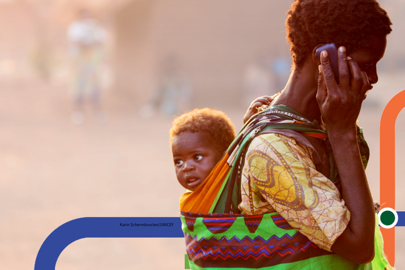 A woman talking with a cellphone and carrying her kid
