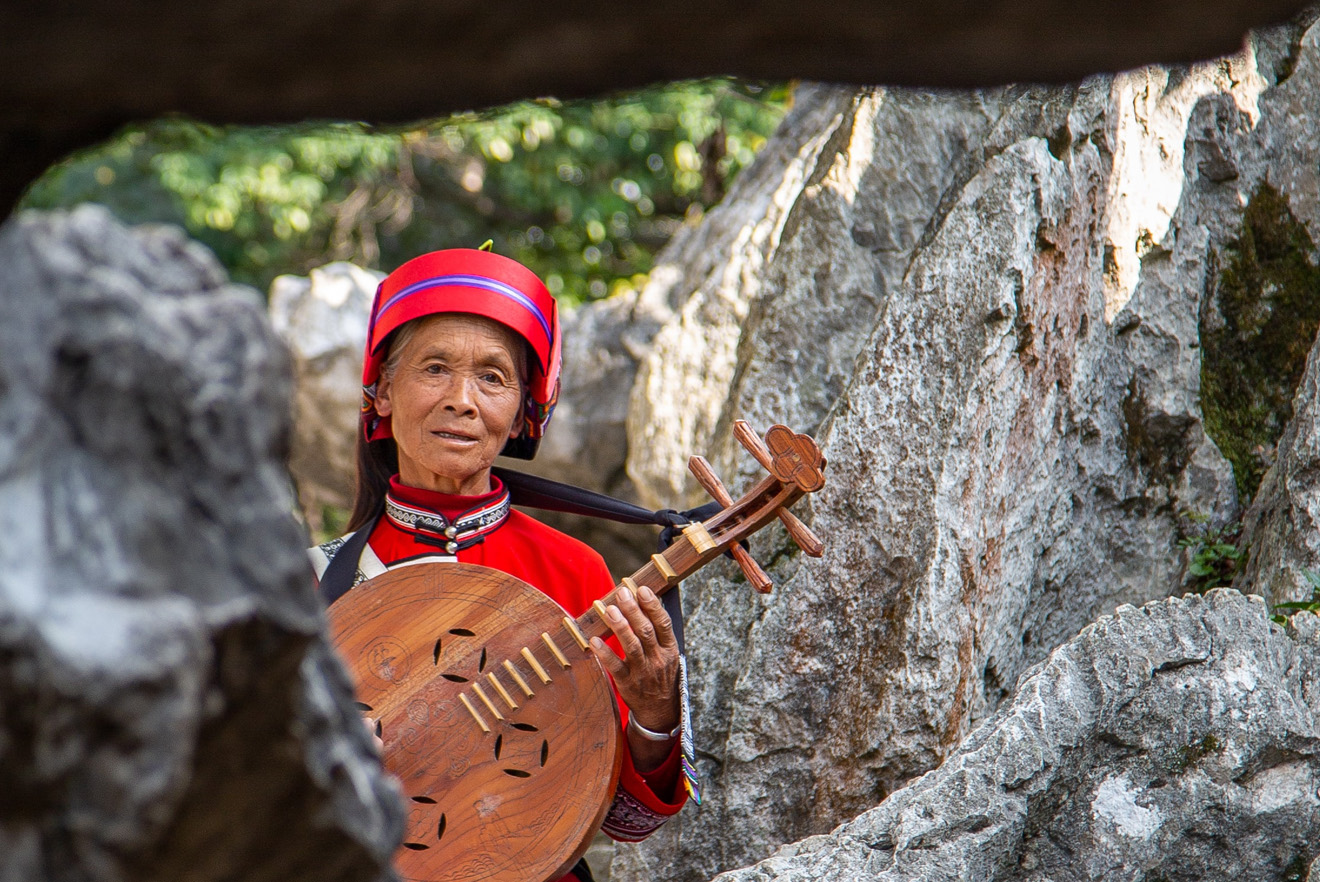 old indigenous woman playing an instrument