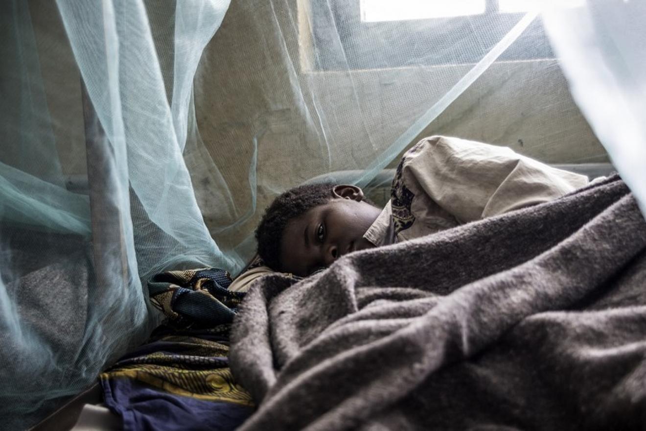 child sleeps under mosquito net