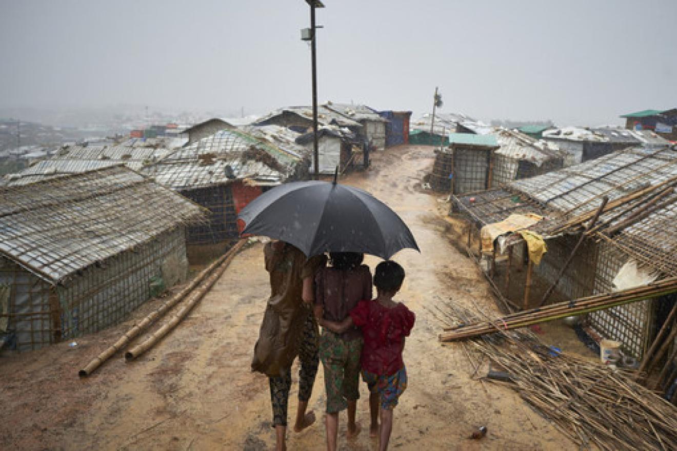 Rohingya refugees make their way down a footpath during a heavy monsoon downpour in Kutupalong refugee settlement, Cox's Bazar district.