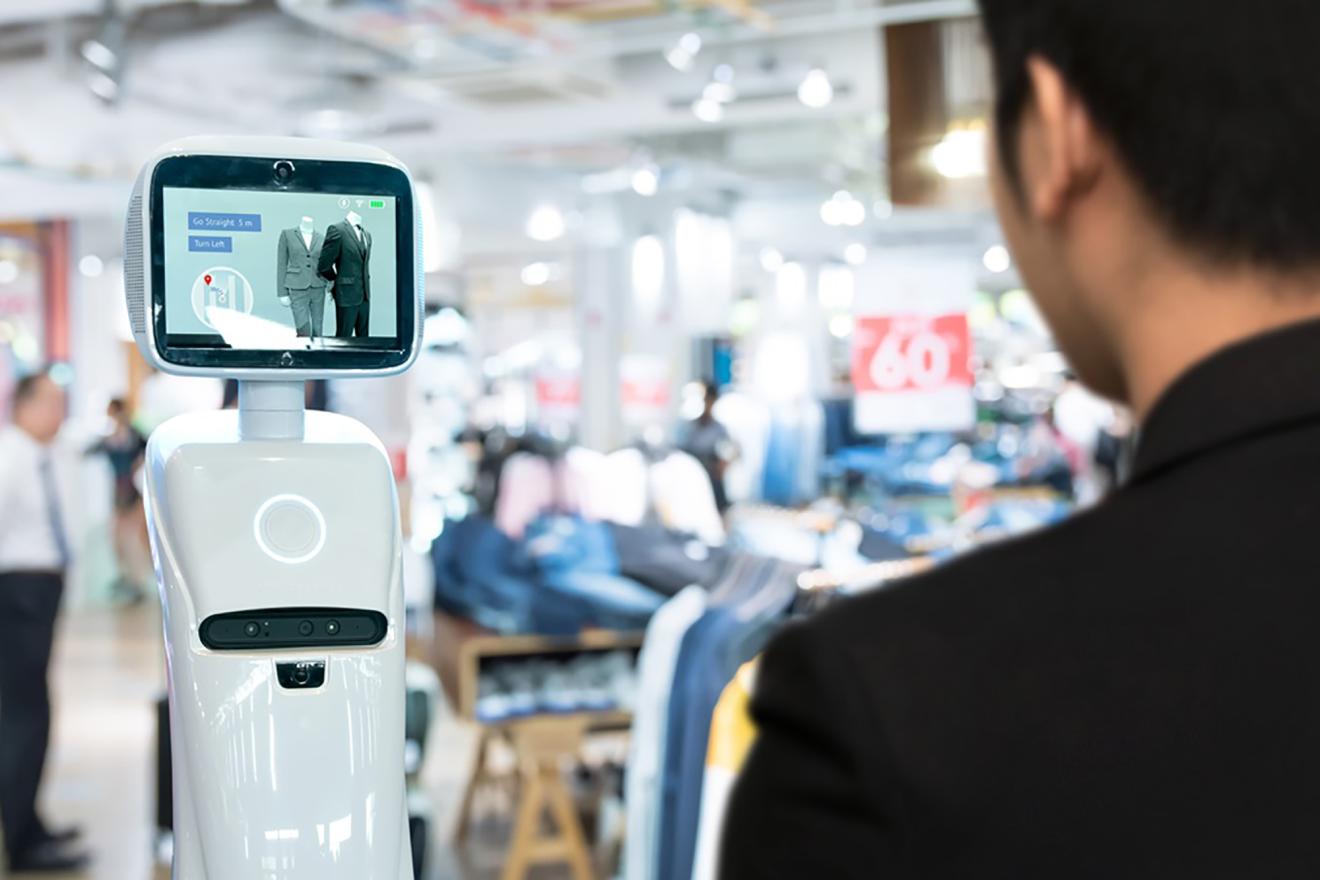 A man interacting with a robot in a shopping mall.