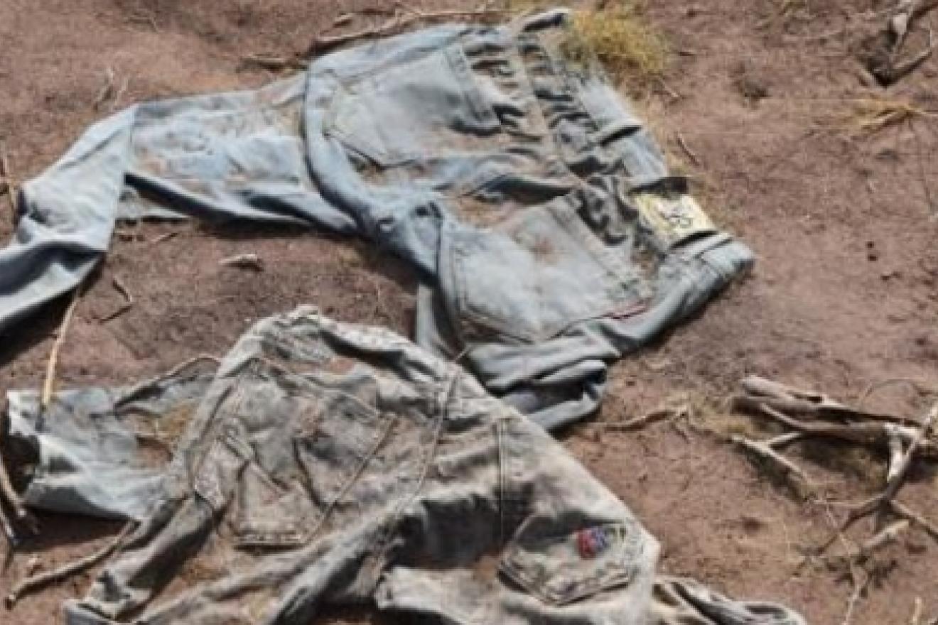 Ropa abandonada y manchada de tierra tirada en un suelo polvoriento.