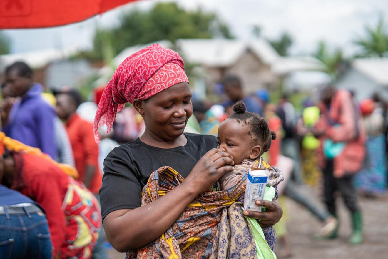 En las afueras de Goma (República Democrática del Congo), una mujer alimenta a su hija pequeña con un tetrabrik de leche del PMA.