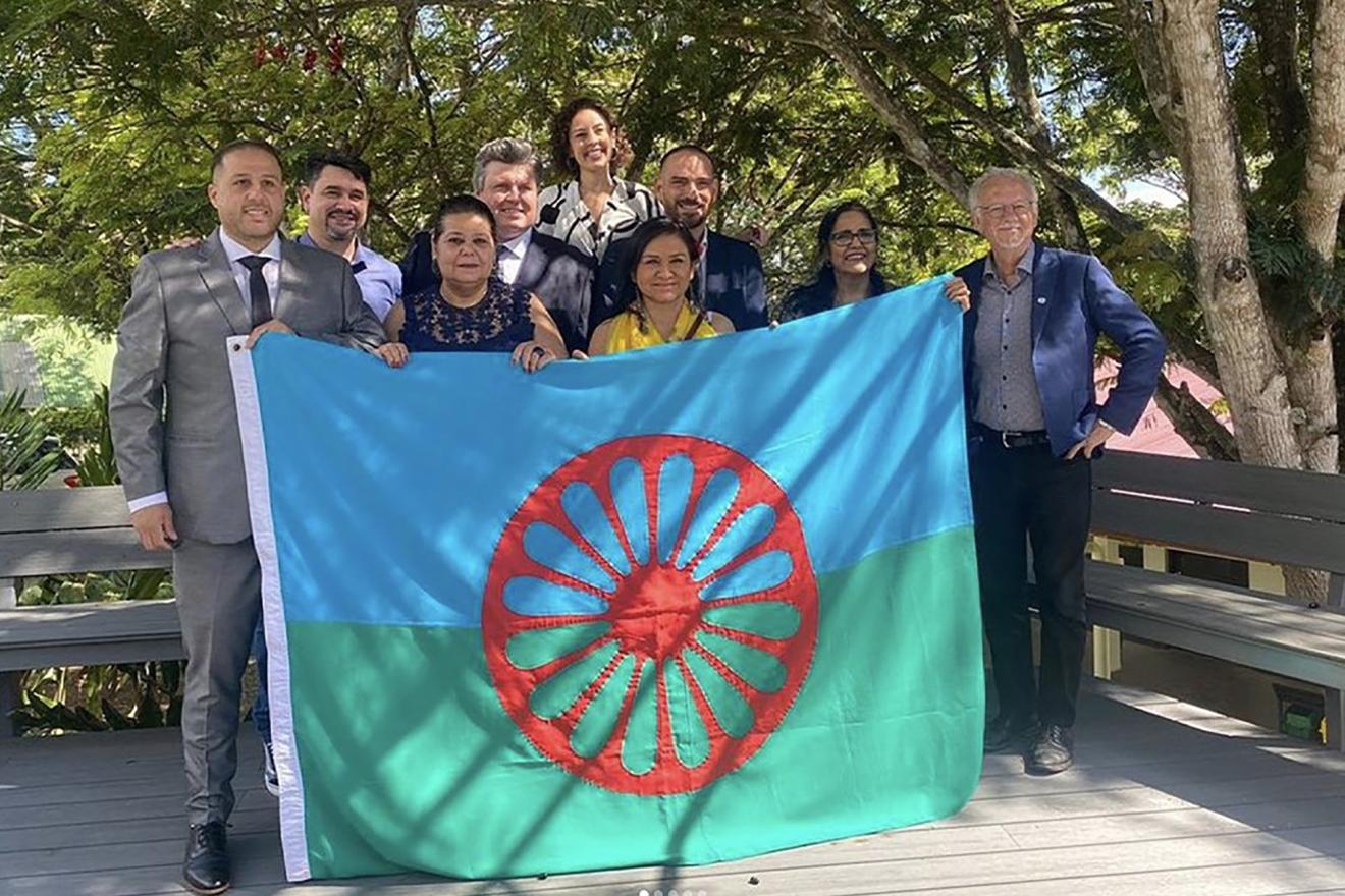 A group of Romani people holding the Romani Flag.