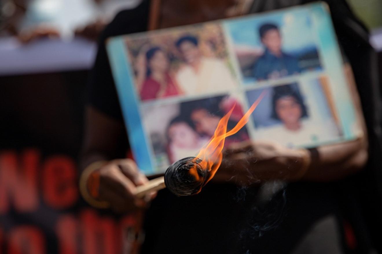 flame in front of photos of missing family members