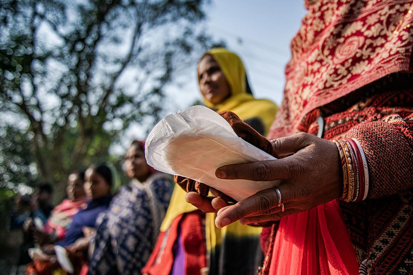 des femmes tiennent entre leurs mains des serviettes hygiéniques lors d’une campagne de sensibilisation 