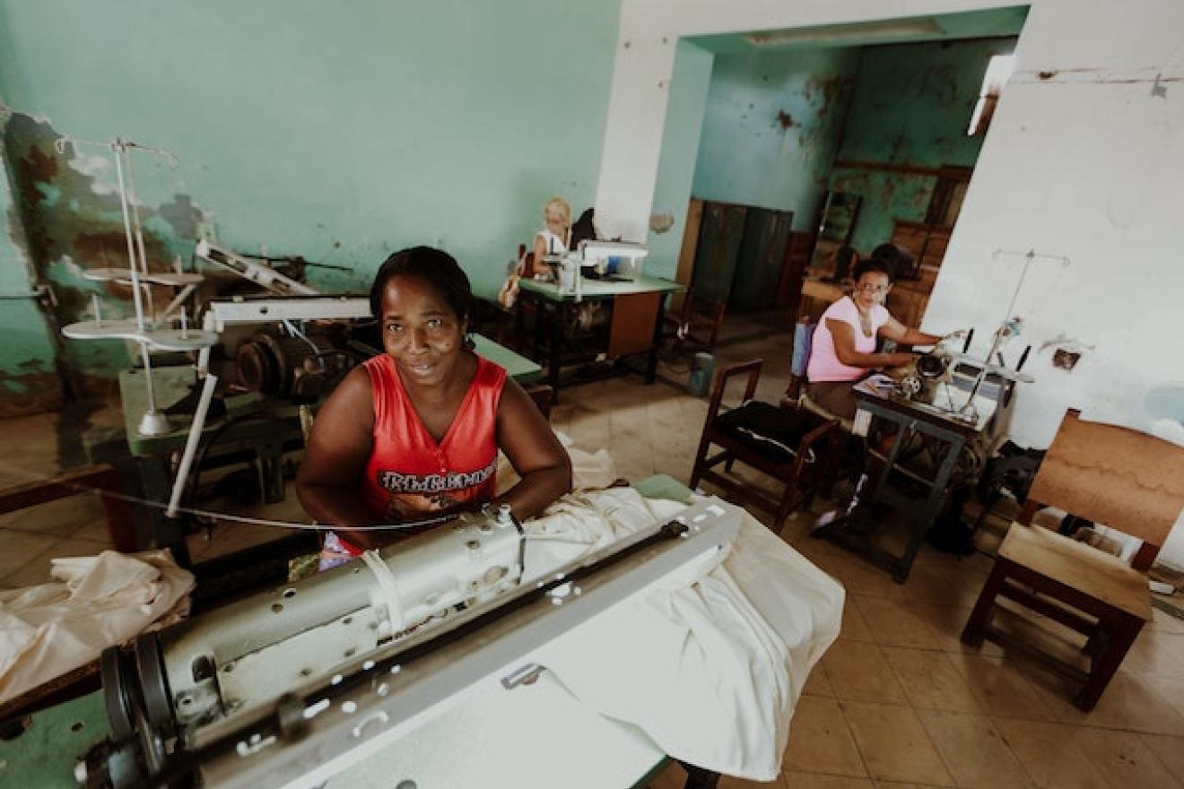 Dos mujeres trabajan en un pequeño un taller de confección textil.