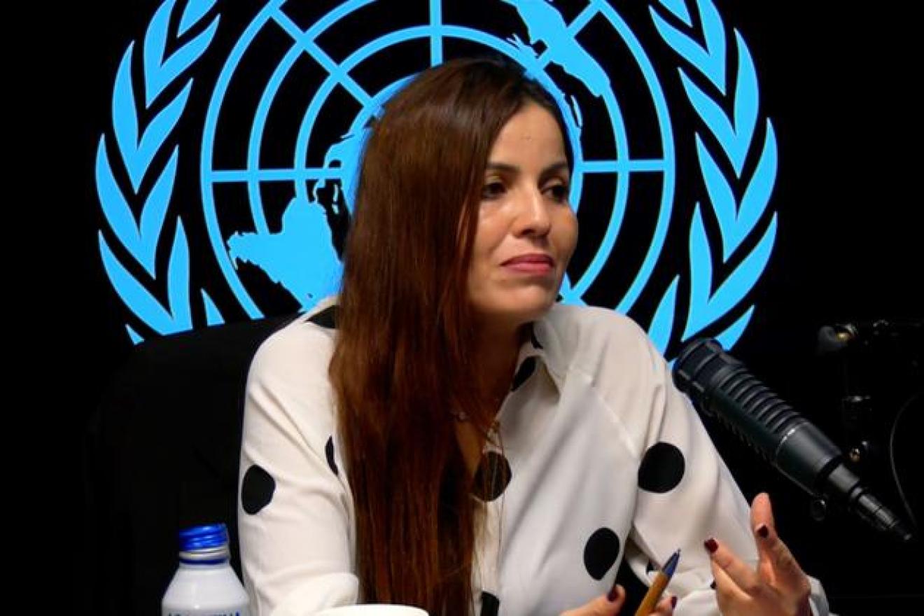 Ahlem Douzi parle devant un microphone radio
